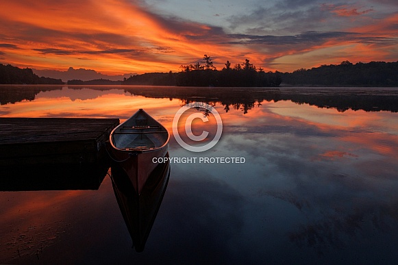 Red canoe at an orange sunrise