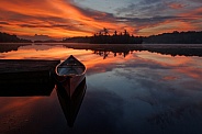 Red canoe at an orange sunrise