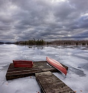 Ice forming on the lake with red canoe