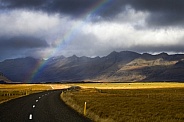 Rainbow over a rural road - Iceland
